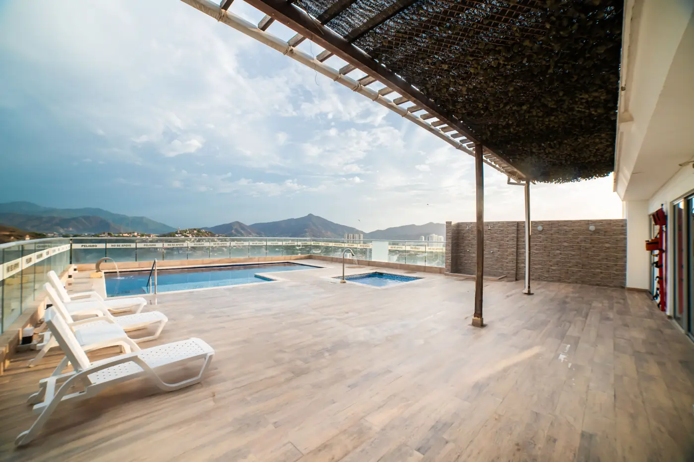 Terraza de la piscina con tumbonas y vista a la Sierra Nevada