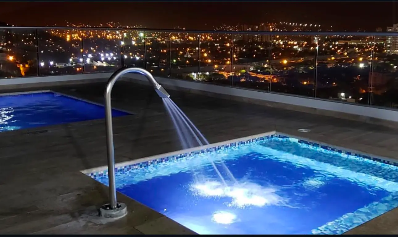 Piscina iluminada de noche con vista a Santa Marta